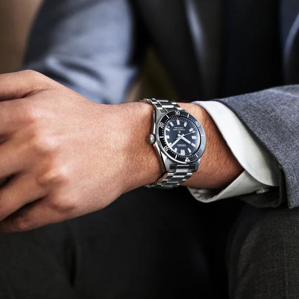 Gent's Seiko Prospex 1965 Heritage Divers 300m Automatic Watch. The 40mm case and bracelet are stainless steel. The bezel and dial are black. The glass is sapphire crystal. The watch has a date function and is 300m water resistant. The movement is automatic