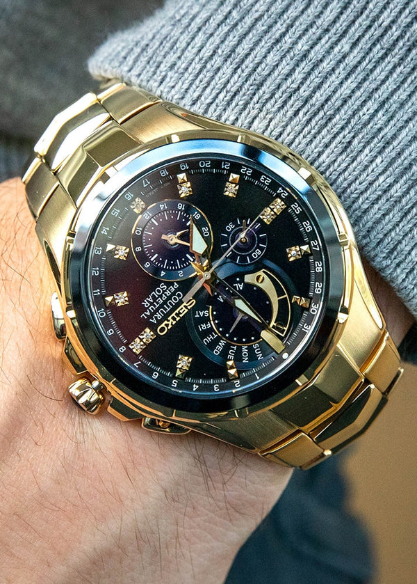 Seiko Coutura Solar Perpetual Calendar Chronograph Watch.  The case and bracelet are yellow gold plated stainless steel, the dial is black and the glass is sapphire crystal. The hour markers are diamond set.