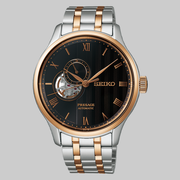 Seiko watch with two-tone metal strap on gray backgroundGents Seiko Presage Japanese Garden Automatic Watch. The 41.8mm case and bracelet are bicolour: rose gold PVD and stainless steel. The dial is black with a textured pattern, rose coloured roman numerals and hands, 24-hour indicator sub-dial and circular shaped movement window. The watch has a sapphire crystal glass with a see-through case back. The movement is automatic. MODEL SSA466J