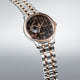 Seiko watch with two-tone metal strap on gray backgroundGents Seiko Presage Japanese Garden Automatic Watch. The 41.8mm case and bracelet are bicolour: rose gold PVD and stainless steel. The dial is black with a textured pattern, rose coloured roman numerals and hands, 24-hour indicator sub-dial and circular shaped movement window. The watch has a sapphire crystal glass with a see-through case back. The movement is automatic. MODEL SSA466J