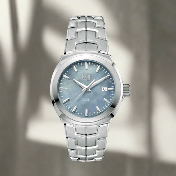 A stainless steel TAG Heuer Link watch with a blue mother-of-pearl dial and a sapphire crystal glass cover, featuring a date function and a silver bracelet.