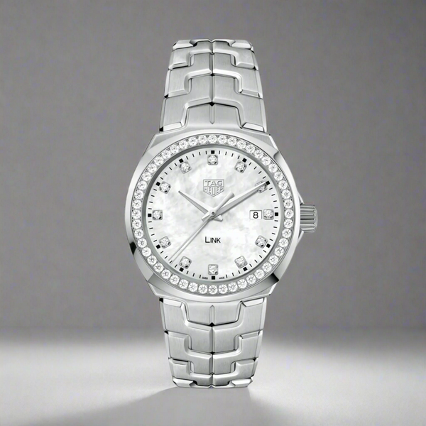 A TAG Heuer ladies quartz watch with a stainless steel case and bracelet, a white mother-of-pearl dial, and a diamond set bezel.