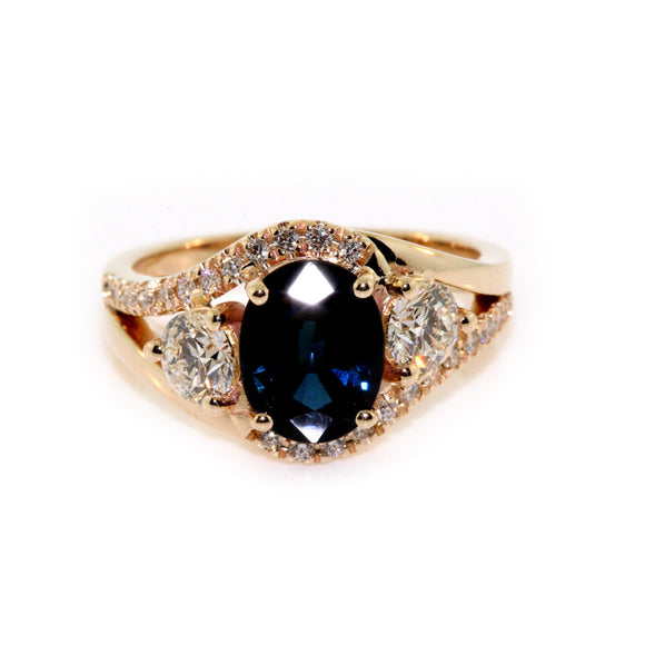 Gold ring with a blue gemstone and diamonds on a white background