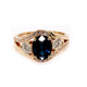 Gold ring with a blue gemstone and diamonds on a white background