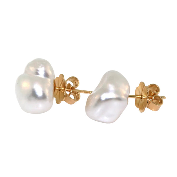 A pair of baroque pearl stud earrings with yellow gold butterfly backings, shown on a plain white background.