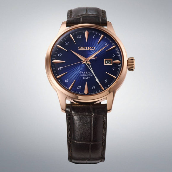 Gent's Seiko Presage Cocktail Time GMT Automatic Watch.

Model: HCB005J

The 40.5mm case is rose gold PVD on stainless steel with a brown leather strap and deployment clasp. The radial patterned dial is blue with rose coloured hands and indexes. The watch has a GMT hand for setting on a second time zone, 24-hour indicators and a date function. The watch has a see-through case back. The movement is automatic.